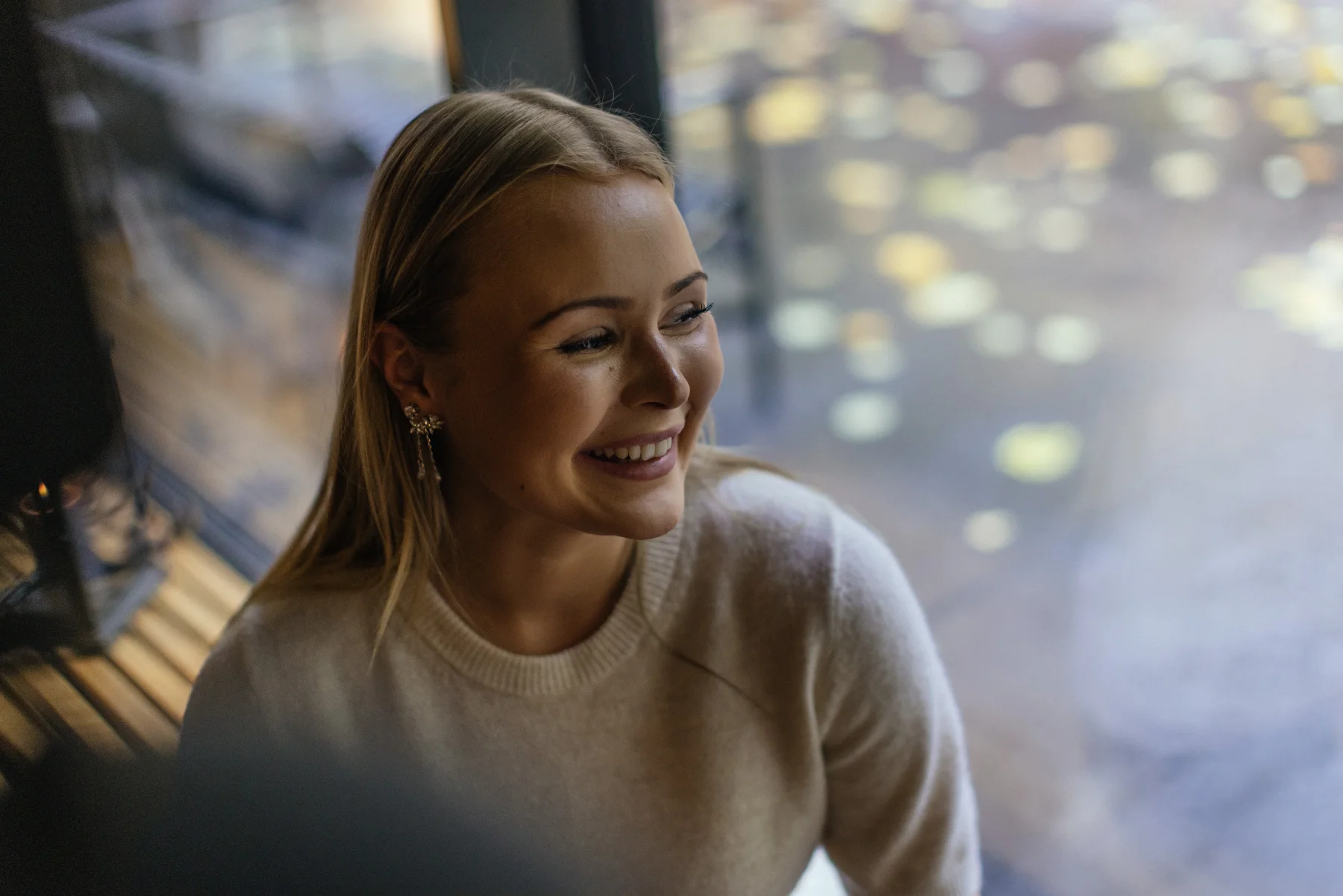 Woman smiling beside a window