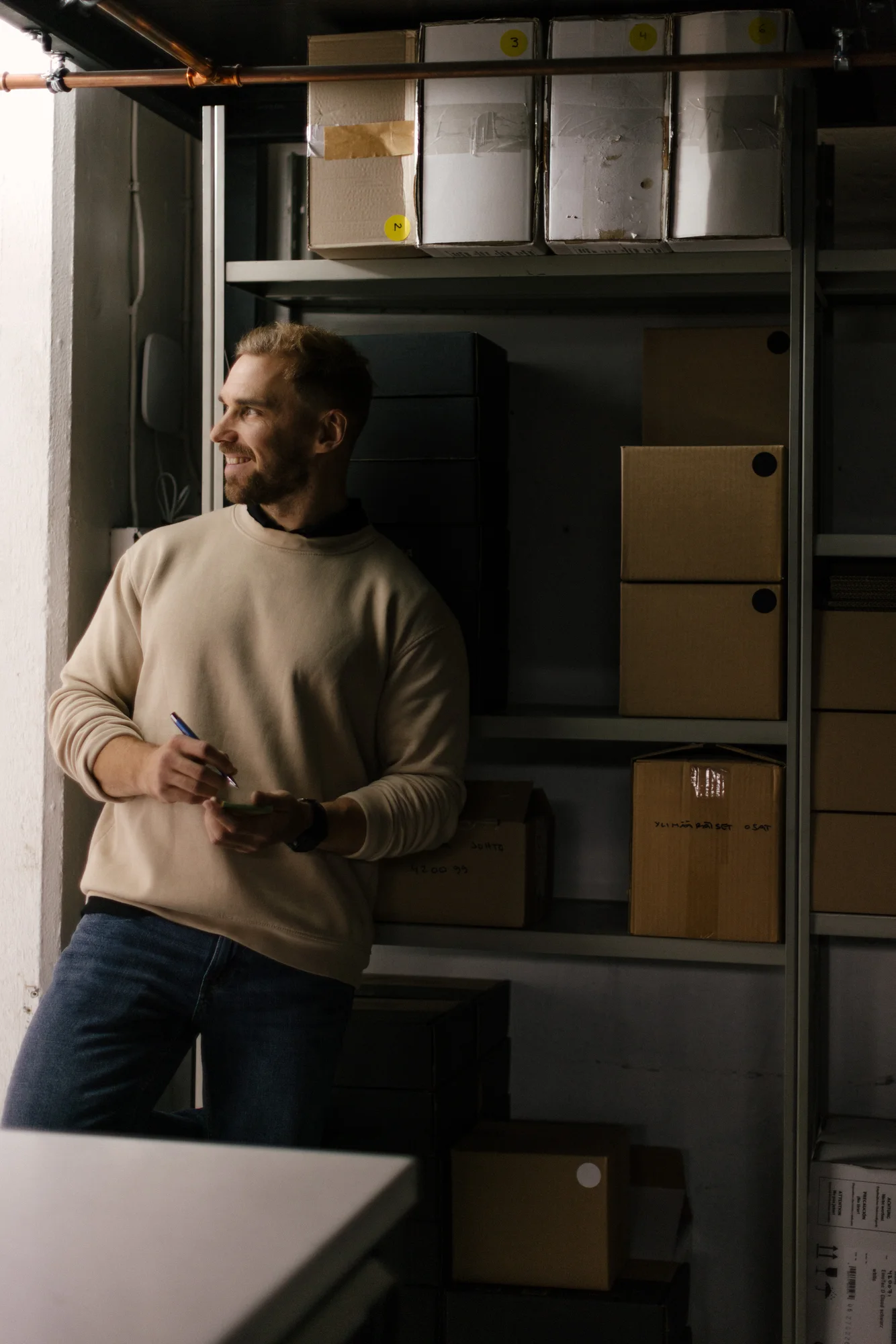 Man with a notebook beside a workshop window