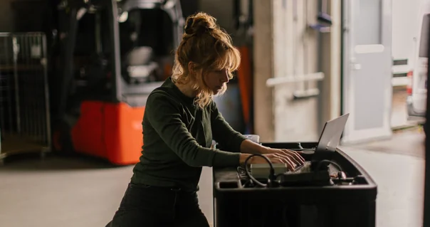 Woman working with a laptop and equipment in a workshop