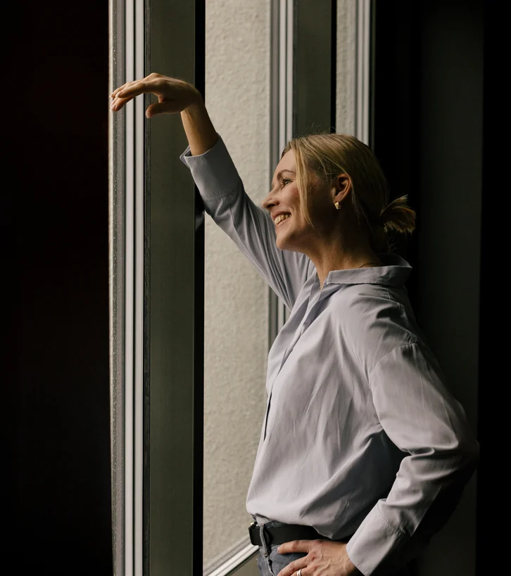 Woman standing beside a window